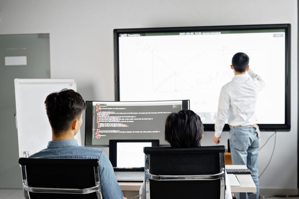 The Art of Drawing Readers In: Your attractive post title goes here Team conducting a business presentation with technology in a modern office setting.